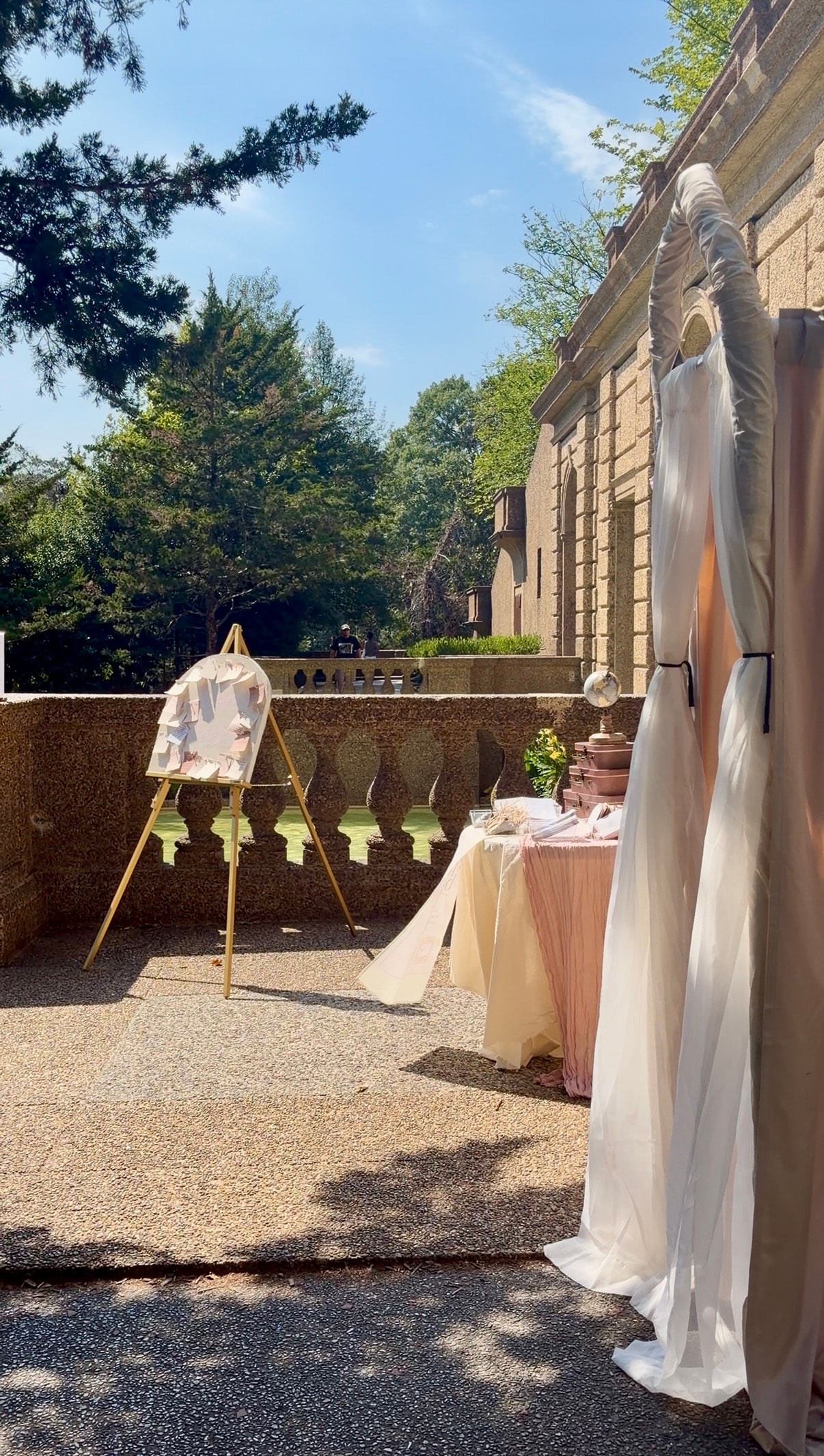 Elegant outdoor activation setup with white draped fabric and gold easel